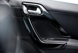 
Vue dtaille de l'intrieur d'une porte de la Peugeot 208. On retrouve des surfaces laques en noir.
 